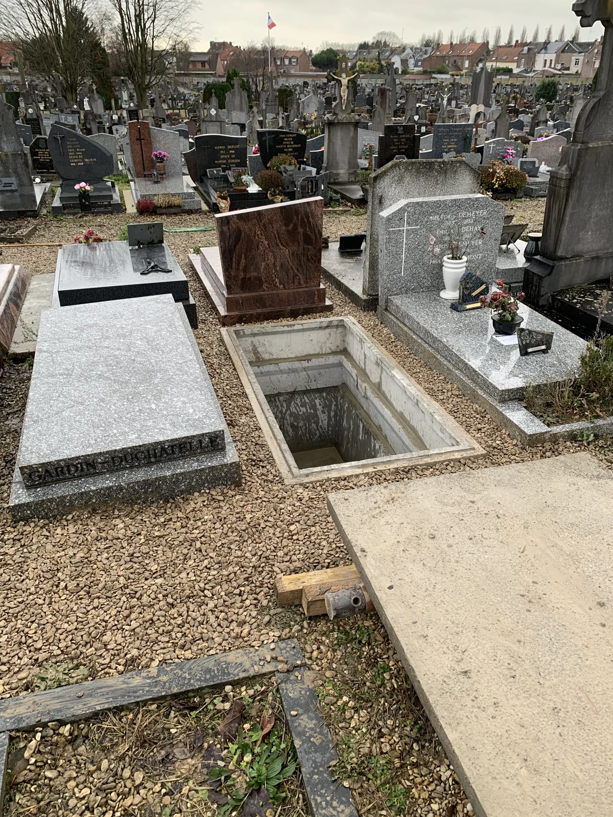 Une sépulture ouverte avec la dalle déposée à proximité
