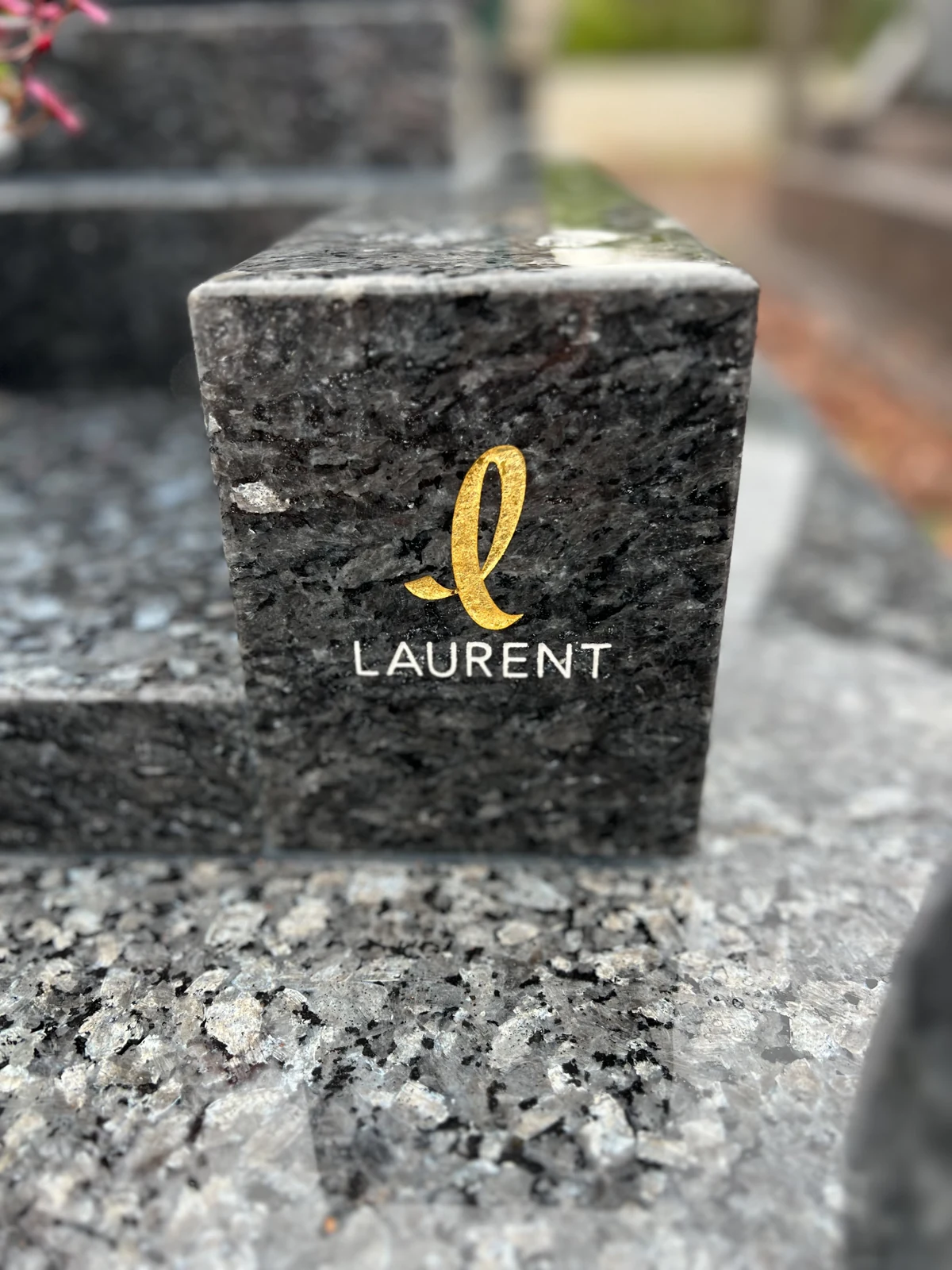 La signature Laurent, dorée sur la pierre
