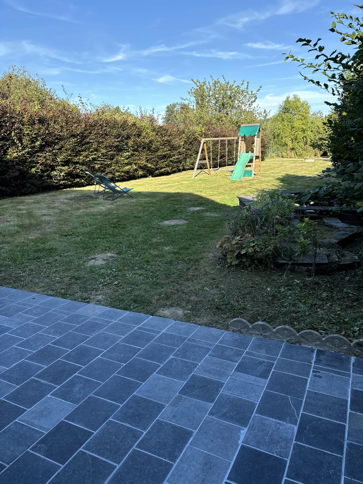 Une terrasse dallée ouverte sur le jardin