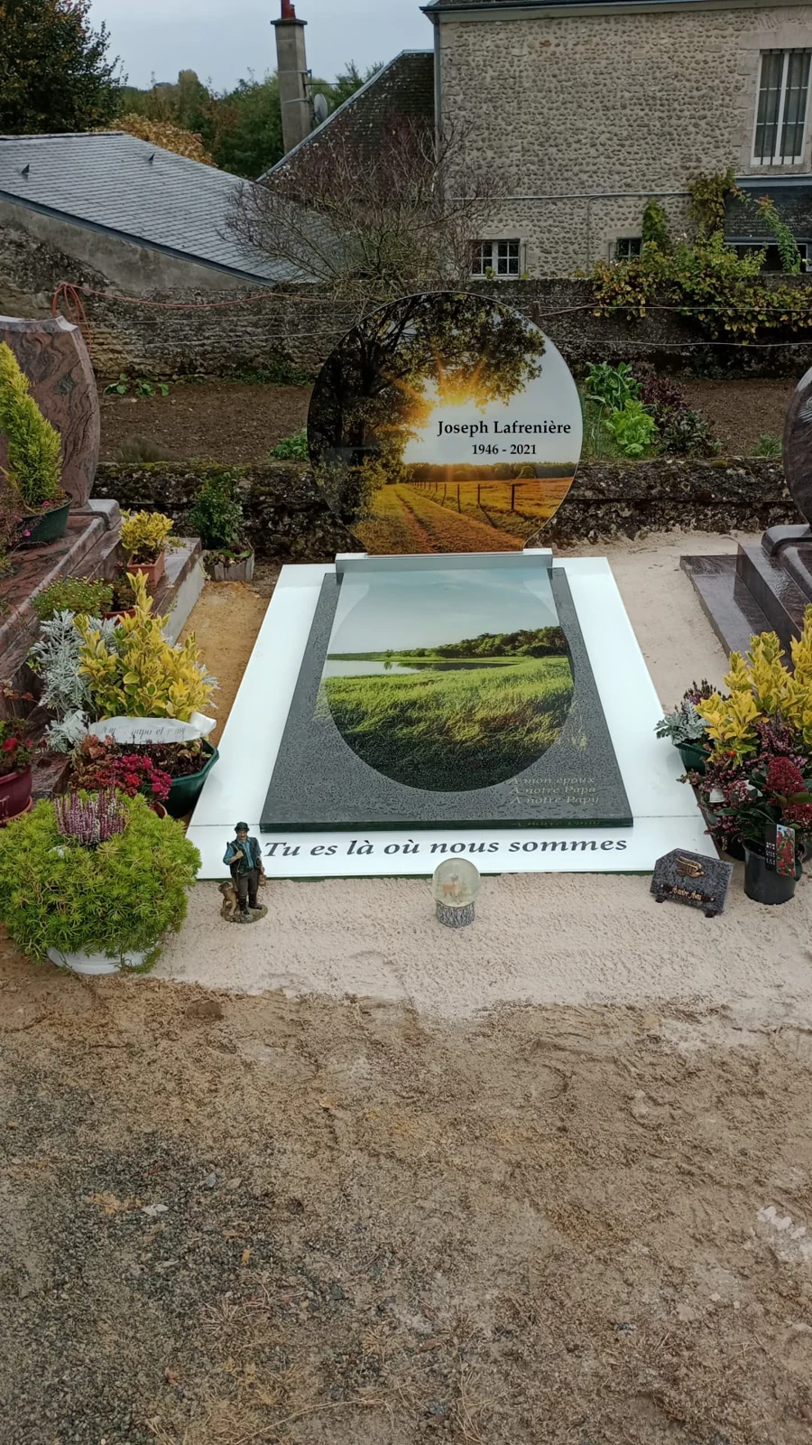 Une stèle arrondie et un paysage de campagne